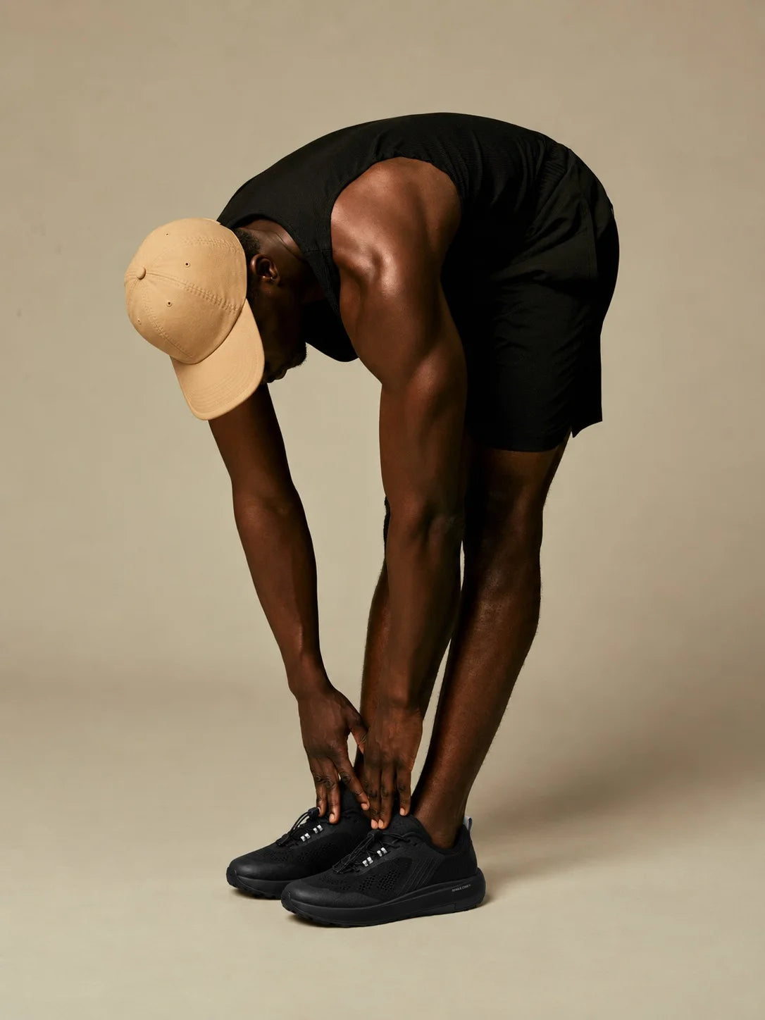 Stretching in black trainers, studio