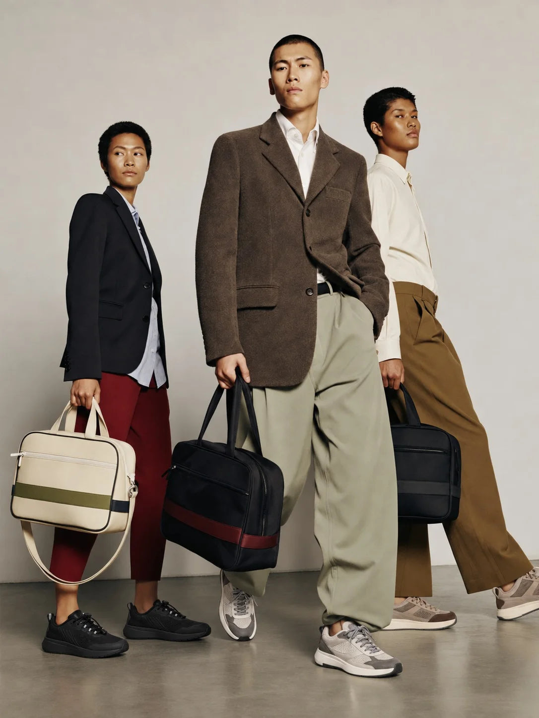 Three men in tailoring carrying gym bags