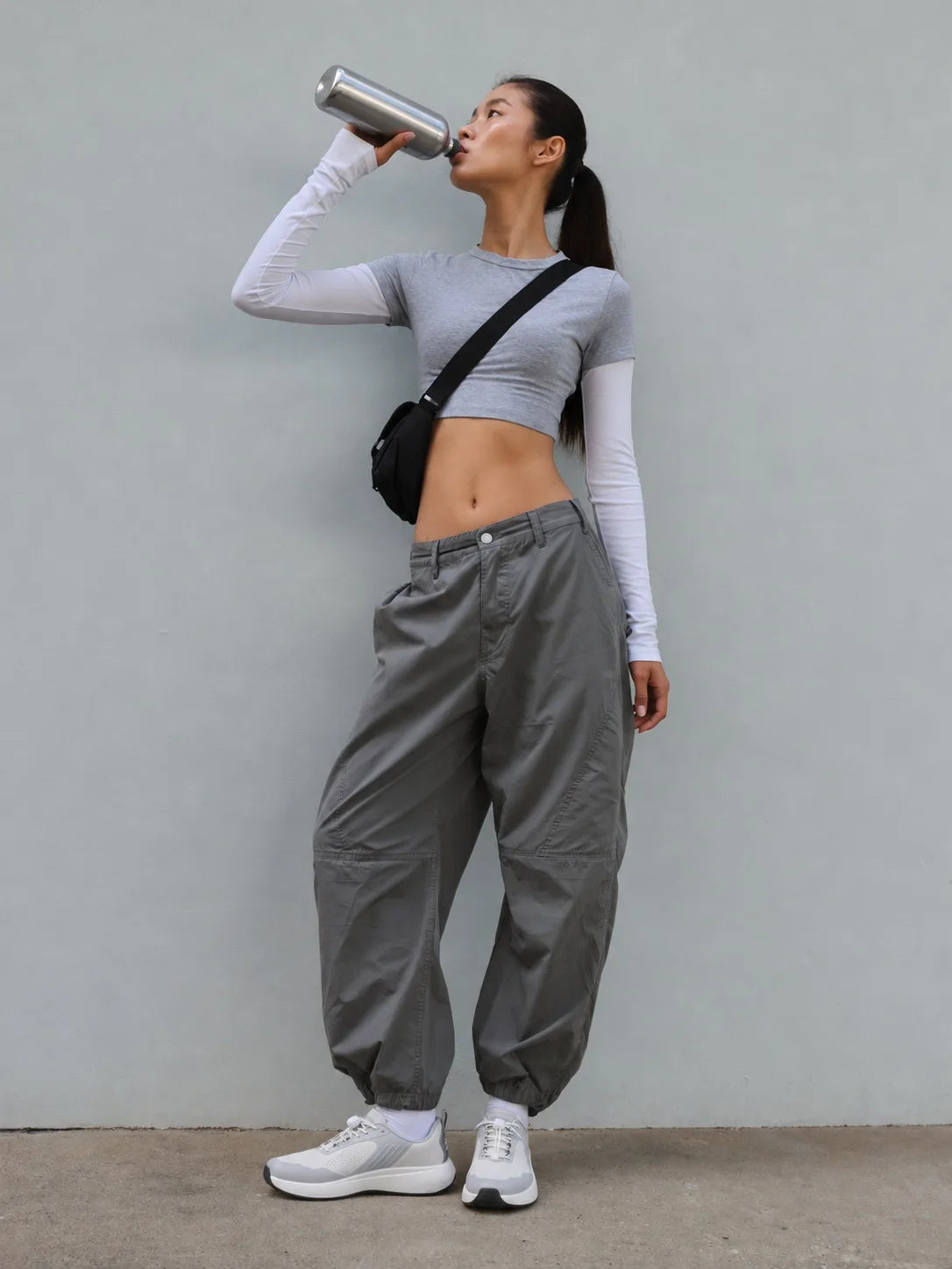 Drinking water against a grey wall