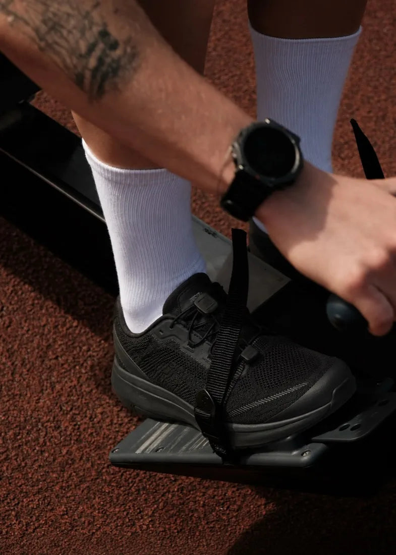 Tightening a lace on a red running track