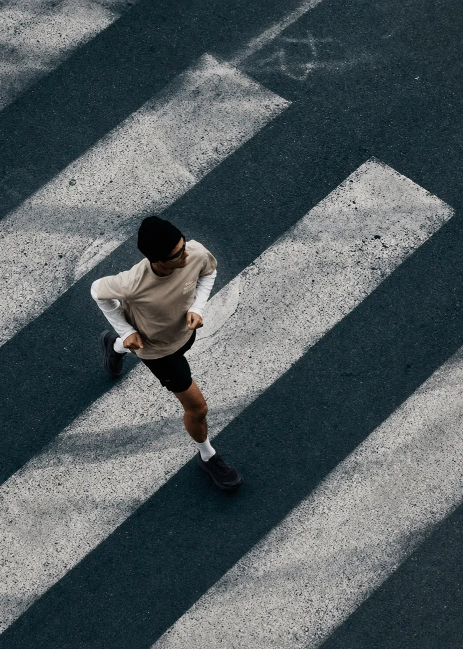 Overhead view of a runner crossing painted road markings