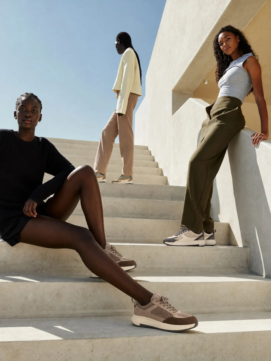 Friends resting on sunlit concrete stairs
