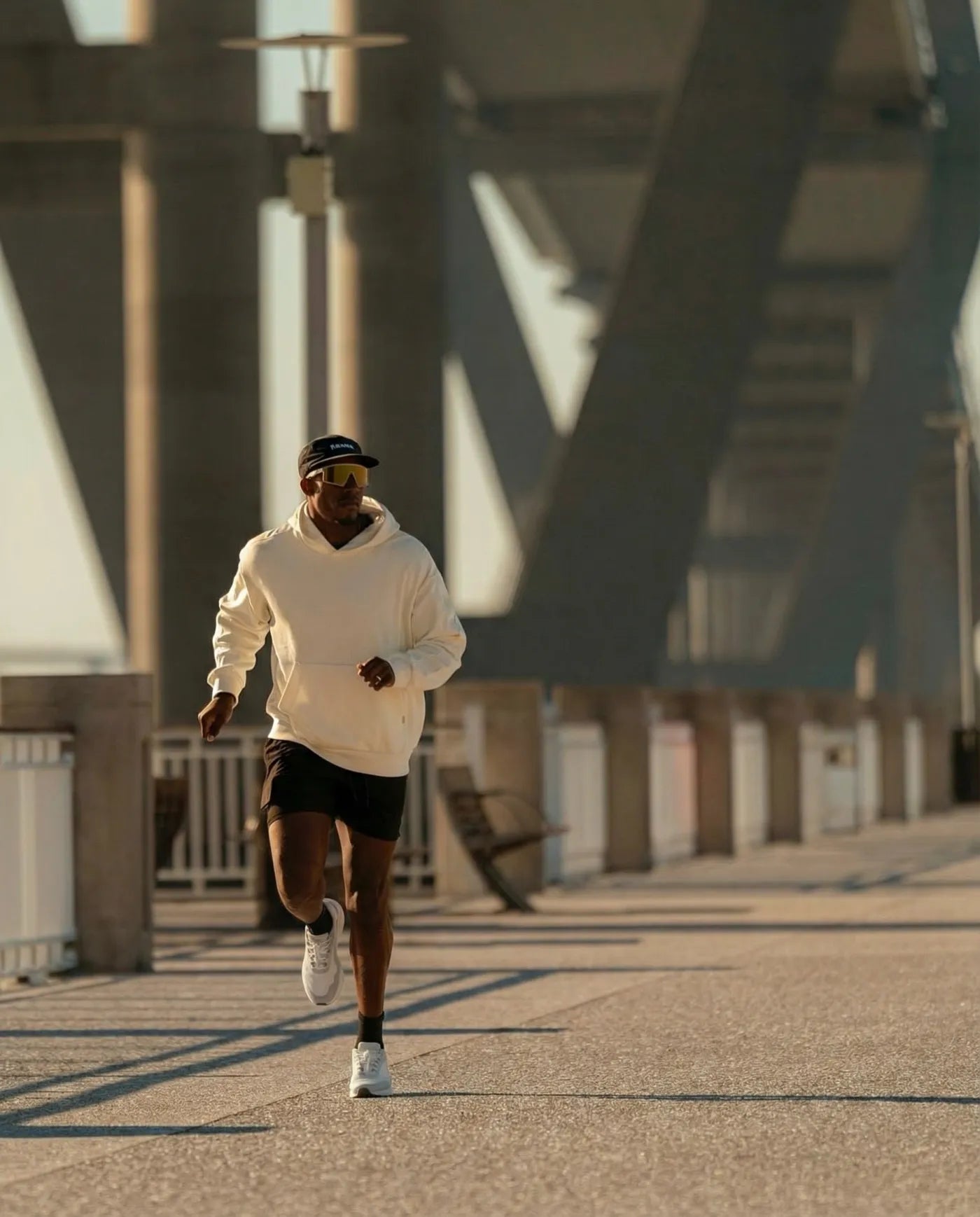 Runner in DARIMATI BR-001 crossing a bridge at golden hour