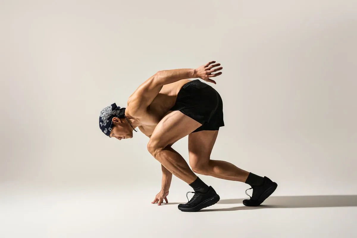 Athlete in a sprint-start stance wearing DARIMATI VT-001 Core Black